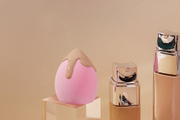 Photo gratuite contenants de fond de teint et beauty blender