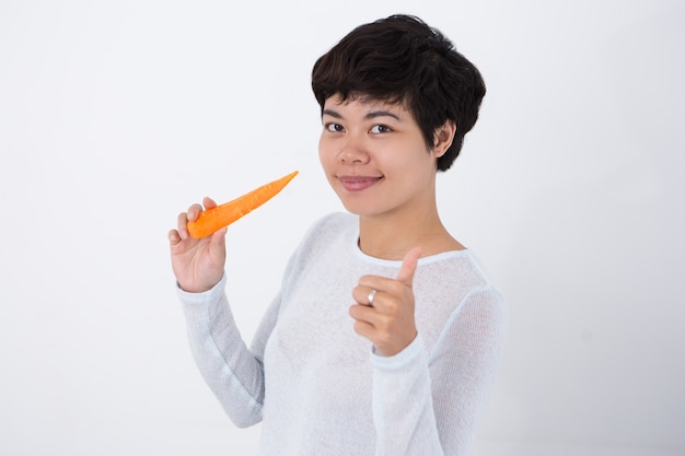 Content Girl Holding Carrot and Showing Thumb Up