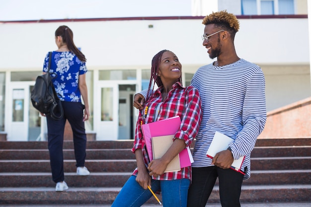 Contenu des étudiants embrassant et posant dans les escaliers