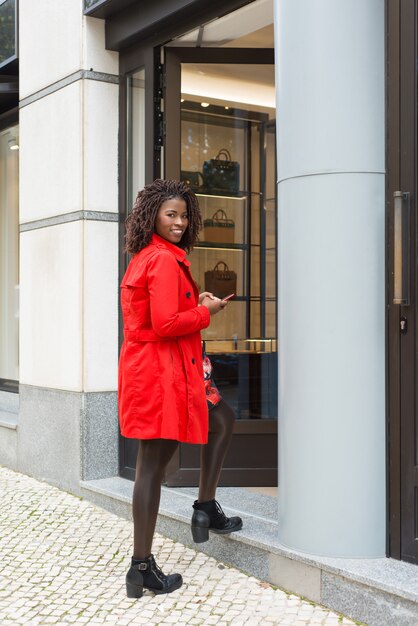 Contenu femme avec smartphone entrant dans la boutique