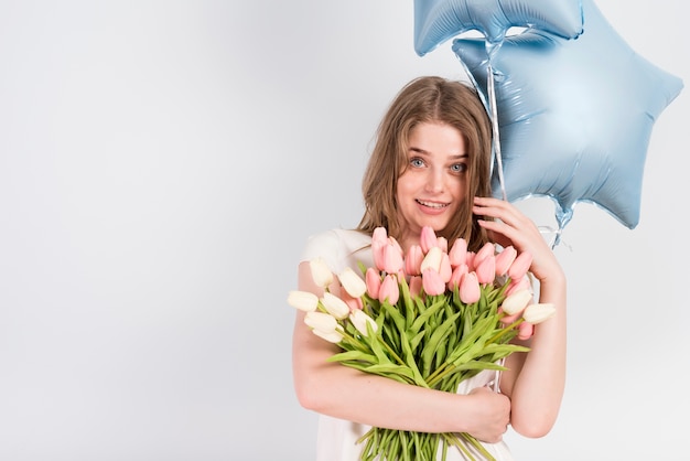 Contenu jeune femme avec des fleurs et des ballons