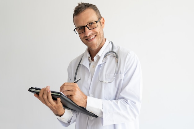 Contenu jeune médecin prenant des notes en papier