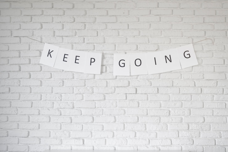 Photo gratuit continuez la guirlande de citation inspirante sur le mur de briques blanches