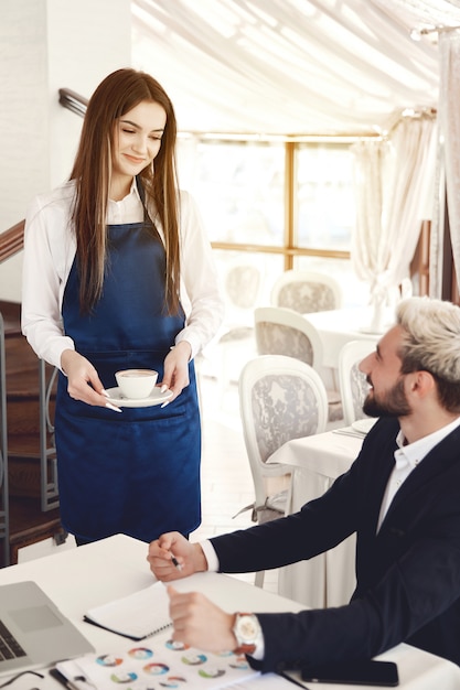 Conversation amusante entre un homme d'affaires et une serveuse au restaurant