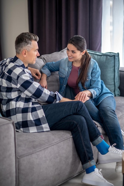 Photo gratuite conversation importante homme attentif sur le côté de la caméra touchant une femme se regardant