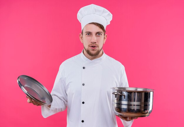 Cook regardant la caméra sortant sur le visage avec pan debout sur mur rose