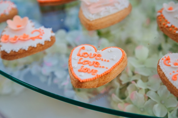 Photo gratuite cookie avec des caractères de glaçure love mensonges sur la table de verre