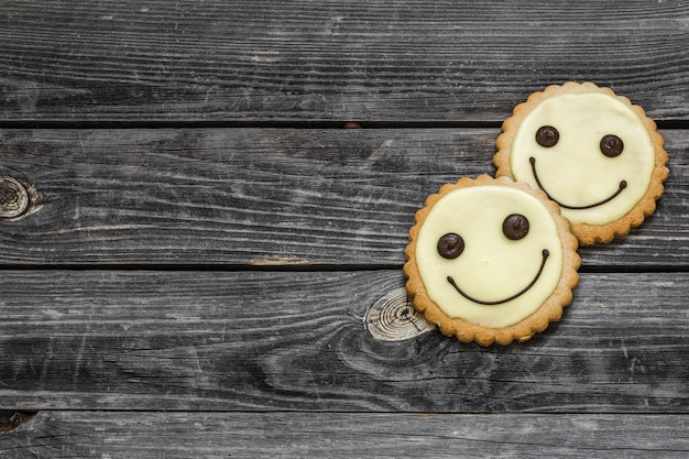 Photo gratuite les cookies sourient sur un beau mur en bois