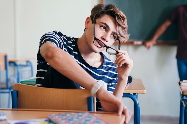 Photo gratuite cool étudiant posant avec ses lunettes