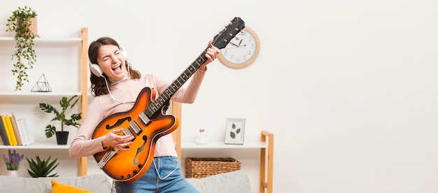 Photo gratuite copie-espace femelle sur canapé avec guitare