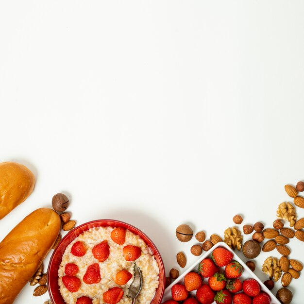 Copier de la bouillie avec des fraises et arrangement de noix sur fond Uni