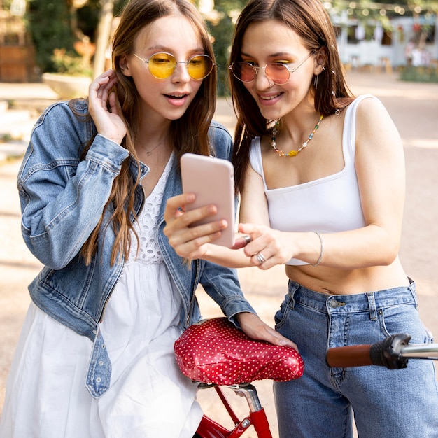 Copines avec vélo vérifiant le mobile