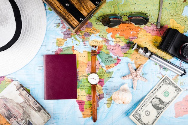 Coquillages, billets de banque, passeport et accessoires sur la carte du monde