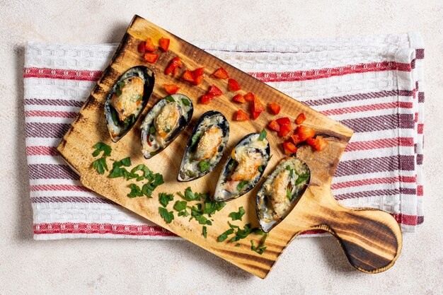 Coquilles de moules savoureuses sur une planche de bois