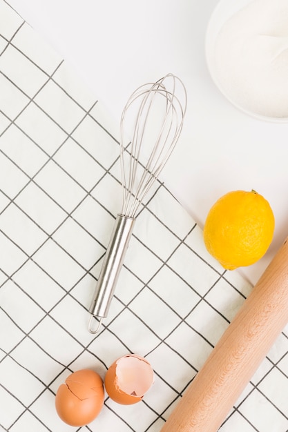 Coquilles d'œuf brisées; citron; sucre et serviette isolé sur fond blanc