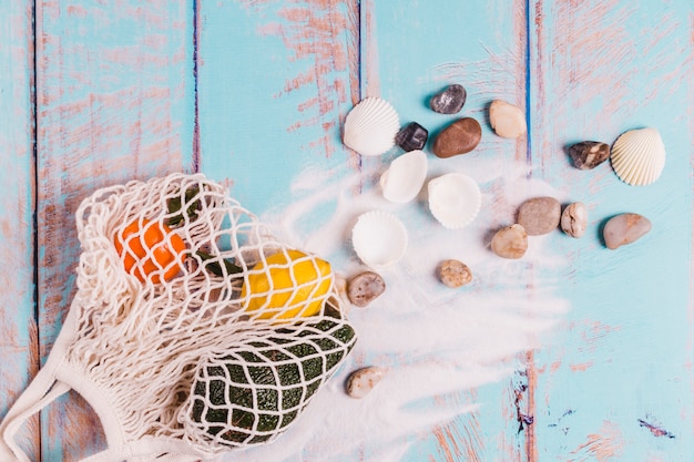 Coquilles pierres sable et fruits sur planche de bois