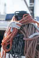 Photo gratuite cordes nautiques, buntine, cabestan et câble empilés sur le pont d'un yacht de course professionnel ou d'un voilier, attachés au mât ou à l'étai, de différentes couleurs