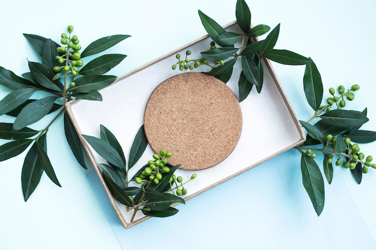 Photo gratuit cork coaster et feuilles dans la boîte sur fond bleu