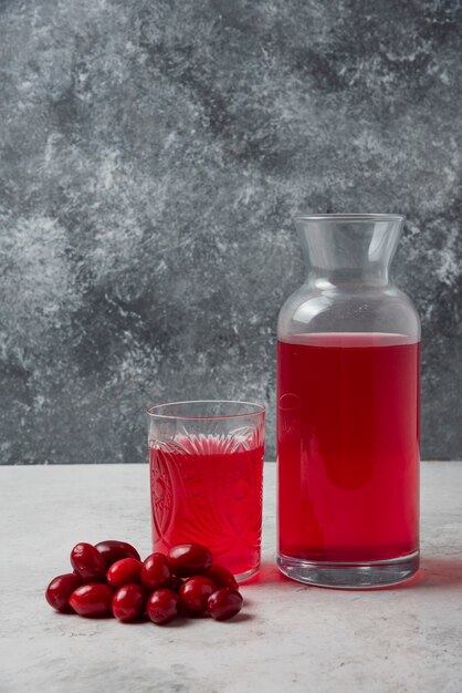 Cornels avec du jus dans le verre et le pot.