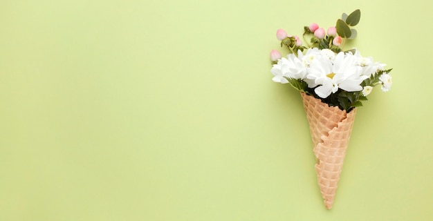 Photo gratuite cornet de crème glacée avec des fleurs