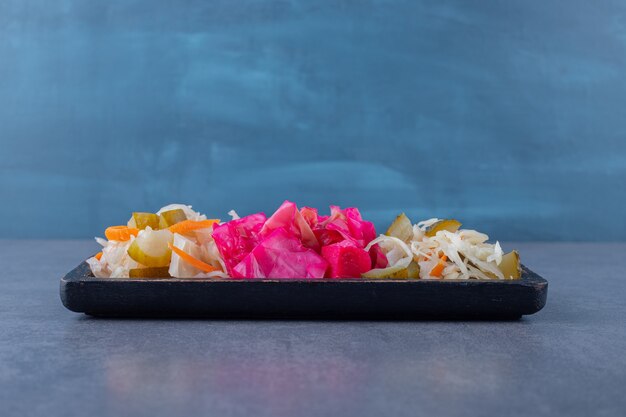 Cornichon au chou fait maison. Haché et choucroute sur planche de bois.