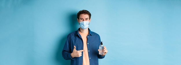 Photo gratuite coronavirus quarantaine et concept de distanciation sociale heureux jeune homme en masque médical recommandant bo