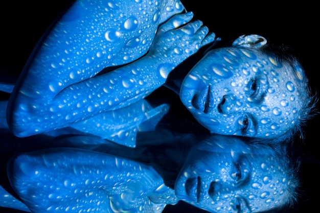 Le corps de la femme avec motif bleu et son reflet