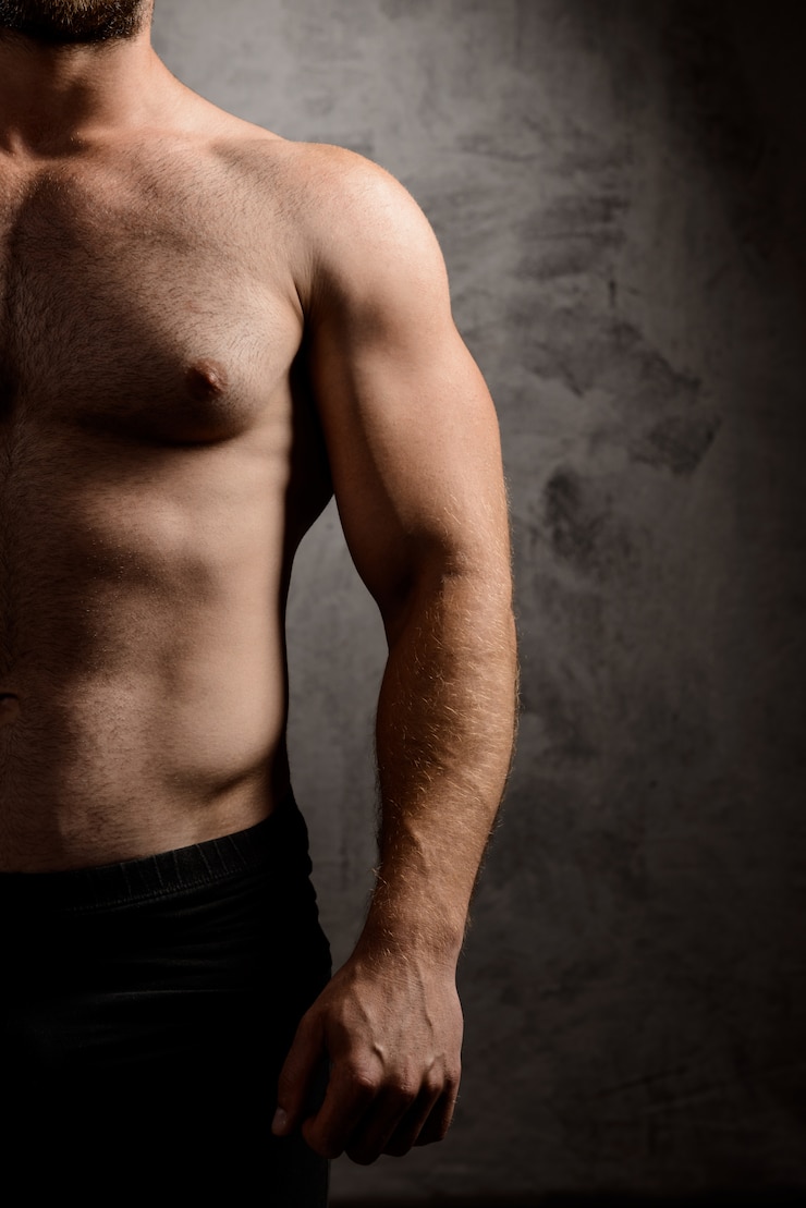 Photo gratuit corps de l'homme sportif sur mur sombre.