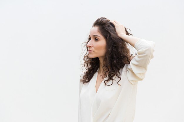 Photo gratuite côté de la belle femme sérieuse pensive touchant les cheveux