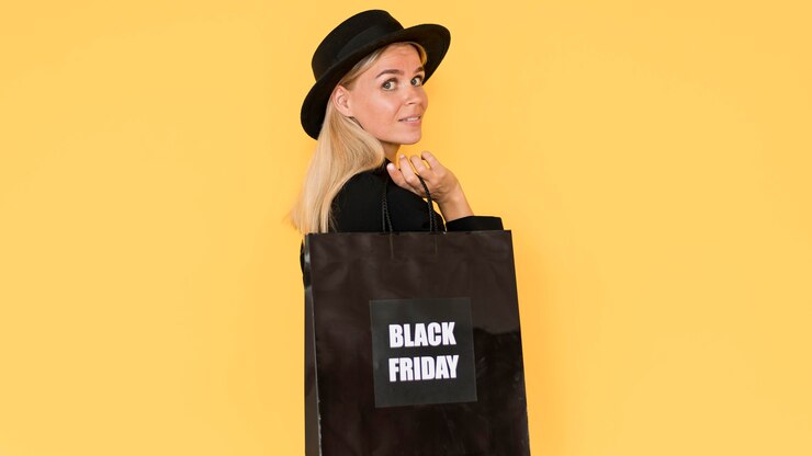 Photo gratuit sur le côté belle femme tenant un sac à provisions vendredi noir