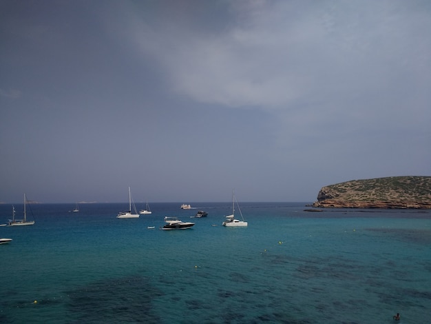 Côte à côté d'Ibiza avec quelques bateaux avant le temps orageux