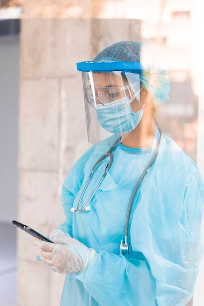 Sur le côté, femme médecin portant un équipement pandémique