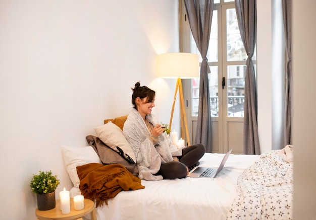 Sur le côté, femme regardant une émission de télévision sur l'ordinateur portable