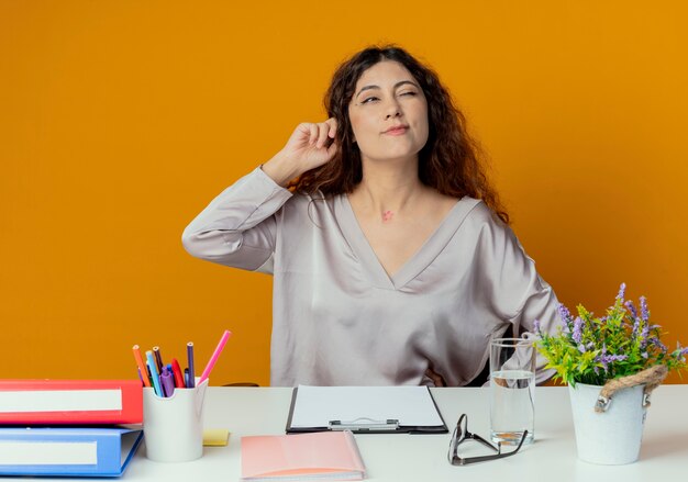 À côté de penser jeune jolie femme employé de bureau assis au bureau