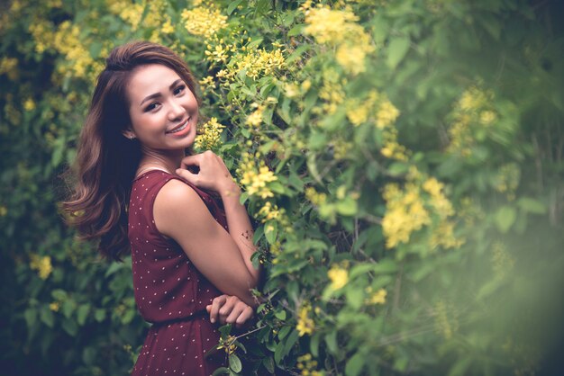 Côté, vue, femme, poser, côté, buisson fleurissant