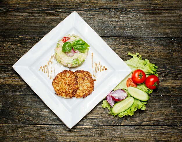 Côtelettes frites avec salade garnie de crème