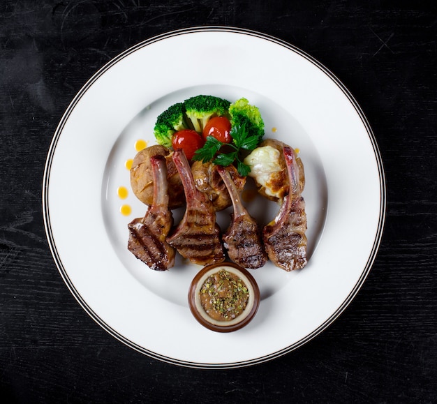 Côtes de viande dans une sauce avec pommes de terre au four et brocoli