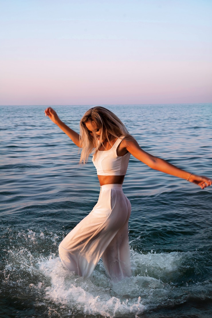 Photo gratuit coucher de soleil femme en haut blanc et pantalon mouillé. tenue bohème.