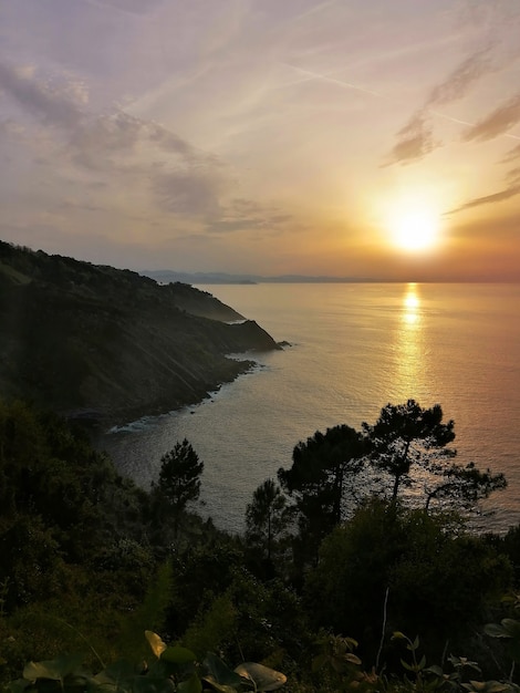 Photo gratuite coucher de soleil hypnotique reflétant dans l'océan à san sebastian, ville balnéaire de l'espagne