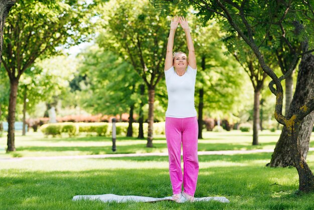 Coup complet vieille femme exerçant dans la nature