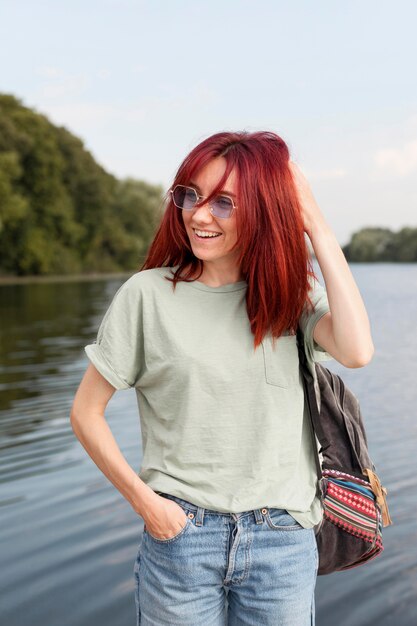 Coup du milieu femme posant devant le lac