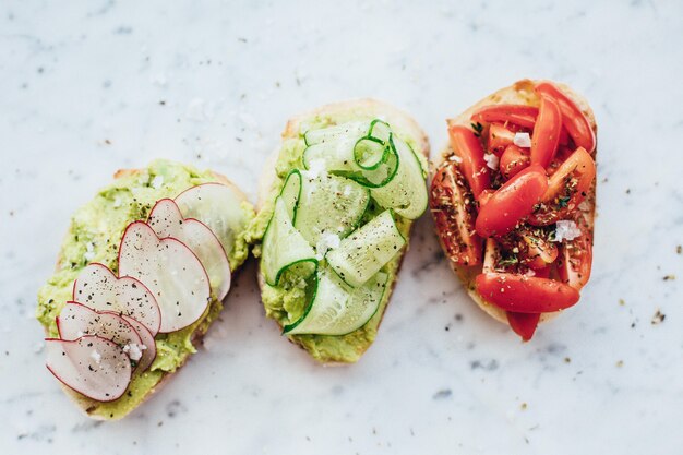 Coup de frais généraux de trois délicieux sandwichs avec sauce à l'avocat sur un fond de marbre