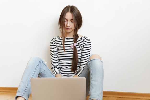 Coup franc de la belle adolescente de race blanche portant ses longs cheveux brune en tresse en désordre