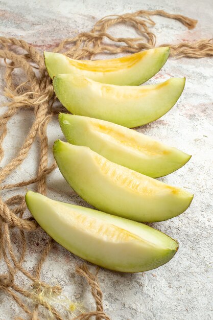 Coup latéral de melons et de corde sur un sol en marbre blanc