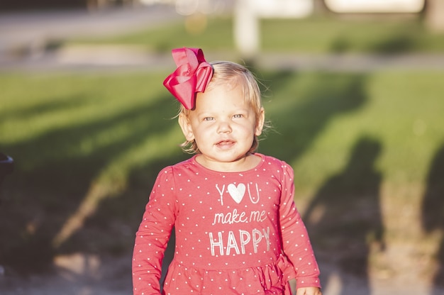 Photo gratuite coup de mise au point peu profonde d'une jeune fille souriante portant un joli arc