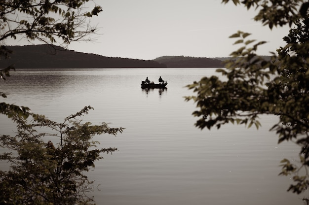 Coup de mise au point sélective d'un bateau sur un lac dans la soirée