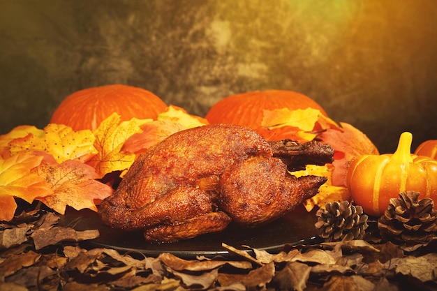 Coup de mise au point sélective d'un panier avec des citrouilles, des feuilles d'automne et un délicieux poulet