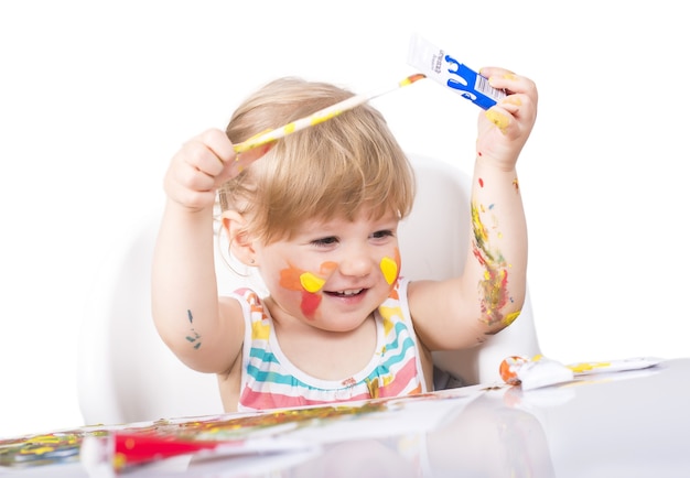 Photo gratuite coup de mise au point sélective d'une petite fille peignant et jouant