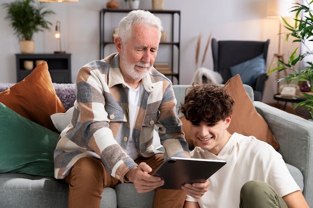 Coup moyen adolescent et homme regardant une tablette