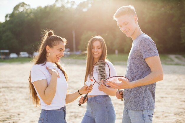 Coup moyen amis heureux avec un équipement de badminton